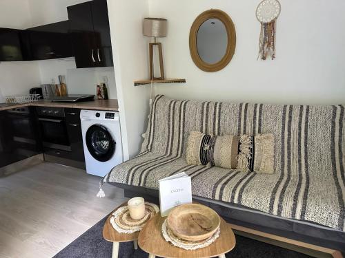 una sala de estar con un sofá y una mesa en Maisonnette studio avec jardin, en Angers