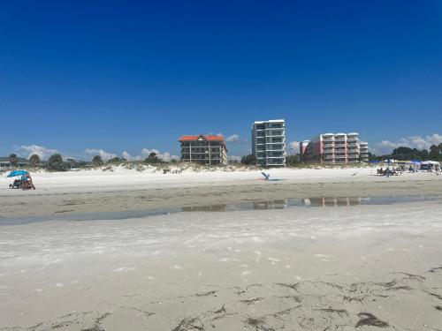 a sandy beach with buildings in the background at Private condo just steps to St Pete Beach in St Pete Beach