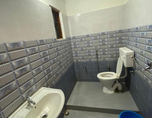 ein Bad mit einem WC und einem Waschbecken in der Unterkunft Hotel Abhinov in Dibrugarh