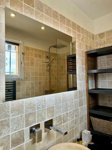 une salle de bain avec un lavabo et un miroir dans l'établissement Dernier étage, vue panoramique Colline du Château!, à Nice