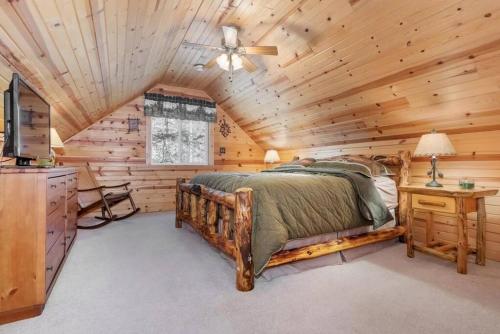 a log cabin bedroom with a bed and a ceiling fan at Cozy House in Quiet place. in Wisconsin Dells