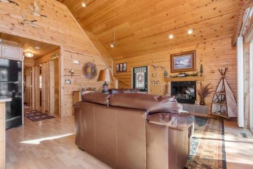 a living room with a large leather couch in a log cabin at Cozy House in Quiet place. in Wisconsin Dells