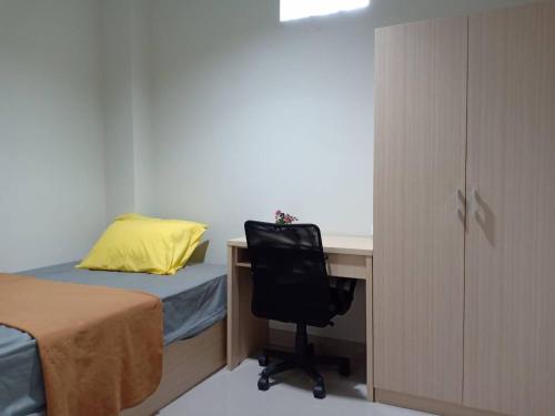 Schlafzimmer mit einem Bett, einem Schreibtisch und einem Stuhl in der Unterkunft Kost Mandala Residence Official (Syariah) in Jakarta