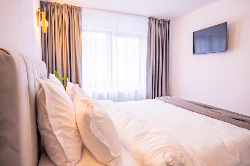 a bedroom with a bed with pillows and a television at Casa Zuz Voronet in Gura Humorului