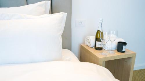 a bed with two glasses of wine on a night stand at Casa Zuz Voronet in Gura Humorului