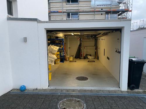 an open garage with a building in the background at Cozy Escape House - 12 min to Zurich HB - Free Parking in Ober Urdorf