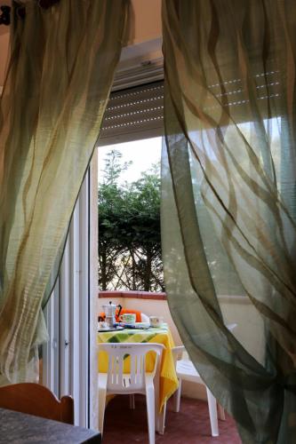 a table and chairs in a room with a window at Villa Medea in Rosolina Mare