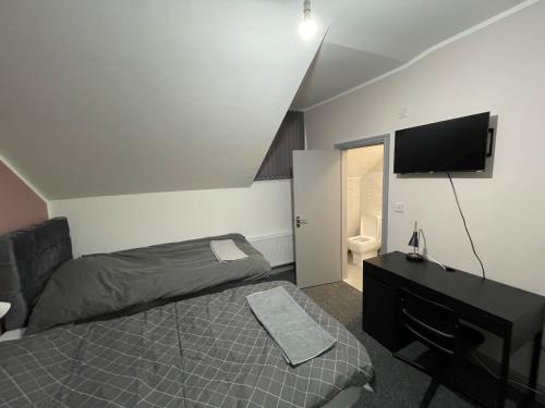 マンチェスターにあるLuxurious En-Suite Room 6のベッドと薄型テレビのある寝室