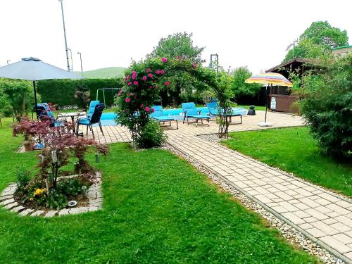 un jardín con mesa, sillas y flores en Apartma Xanadu, en Slovenske Konjice