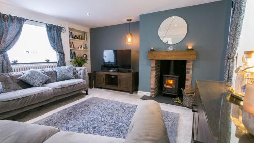 a living room with a couch and a fireplace at Bwthyn Bryn Gwyn in Beaumaris