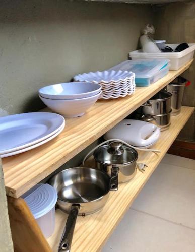 a wooden shelf with plates and bowls and dishes at Casa Macao Pipa in Pipa