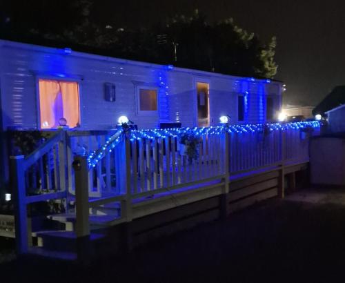ein Haus mit blauen Lichtern an einem Zaun in der Unterkunft the poplars lyons robin hood in Meliden