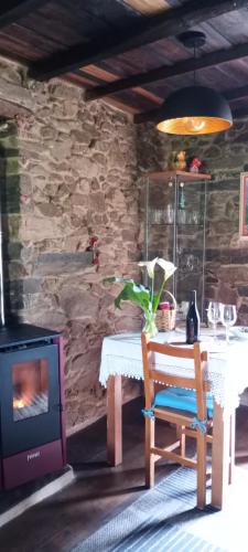 a dining room with a table and a wood stove at Casita de Florita in Doade