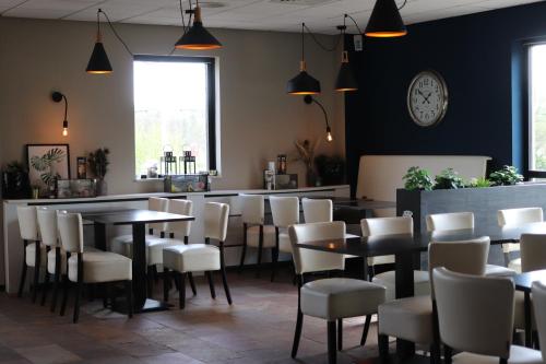 a restaurant with tables and chairs and a bar at Comfortabel 6p vakantiehuis met laadpaal in Ewijk