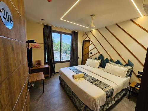 a hotel room with a bed and a window at Hotel Nova Palm in Rajkot