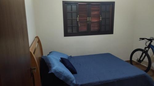 ein Schlafzimmer mit einem Bett und einem Fahrrad neben einem Fenster in der Unterkunft Estalagem Nogueira in Cunha