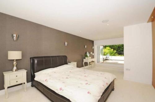 Tempat tidur dalam kamar di Captivating 5-Bed House in Woking
