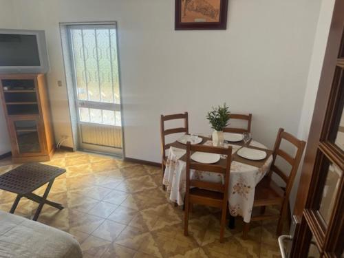 a dining room with a table and chairs and a television at Appart FAFE in Meidelo