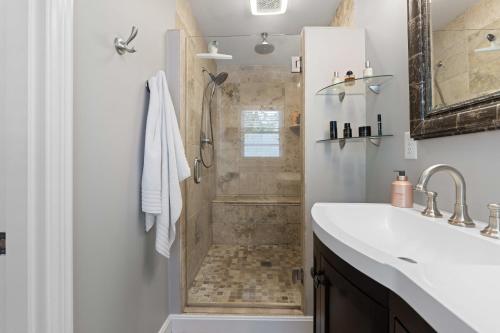 uma casa de banho com um chuveiro e um lavatório. em Cozy Hub near Louisville's Attractions w Office em Louisville