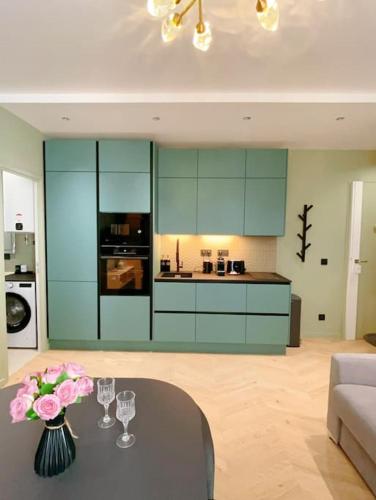 - une cuisine avec une table avec des verres et des fleurs dans l'établissement Appart close to Eiffel Tower, à Paris