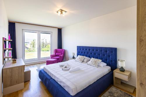 a bedroom with a blue bed and a purple chair at Ilidza River Apartments in Sarajevo