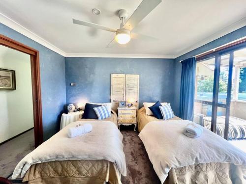 1 dormitorio con 2 camas y pared azul en French Boutique Loft Apartment @Chapmans+breakfast, en Moss Vale