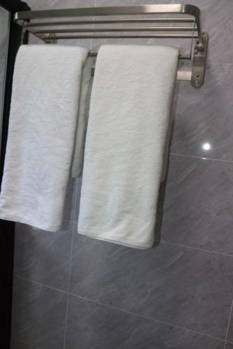three towels are hanging on a towel rack in a bathroom at 3 bedroom ensuite apartment Lavington in Nairobi