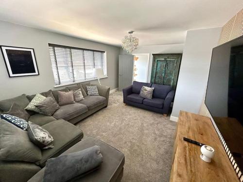 a living room with a couch and a table at Unique & Pet Friendly Luxury Retreat With Hot Tub in Horsham Saint Faith