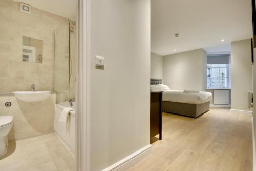 a bathroom with a shower and a bedroom with a bed at Orange Grove Hotel & Gardens in Southampton