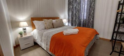 a bedroom with a bed with an orange blanket at Villa City in Funchal
