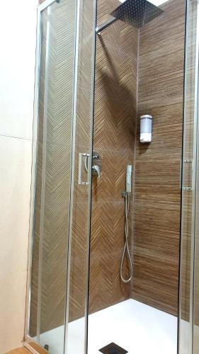 a shower with a wooden wall in a bathroom at Il Giramondo in Aversa