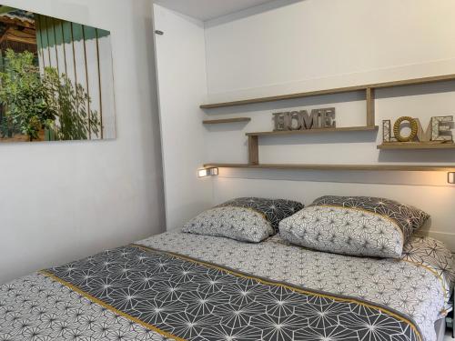 um quarto com uma cama com duas almofadas em Altéa em Pessac