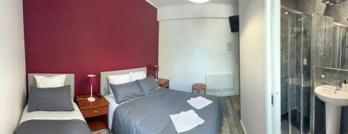 a bedroom with two twin beds and a sink at LE MEDITERRANEEN Montargis in Montargis