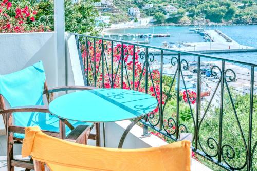 a balcony with a table and chairs and a view of the water at Patras Apartments in Fournoi