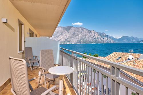 a balcony with chairs and a view of the ocean at Hotel Astoria - 3stelle S in Malcesine