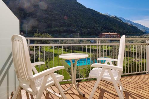 two chairs and a table on a balcony with a mountain at Hotel Astoria - 3stelle S in Malcesine