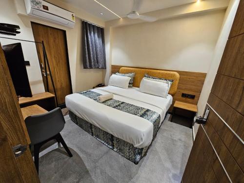 a hotel room with a bed and a television at Hotel Nova Palm in Rajkot