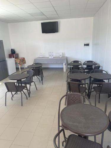 a room with tables and chairs and a tv at B&B Villa Anna in Sibari