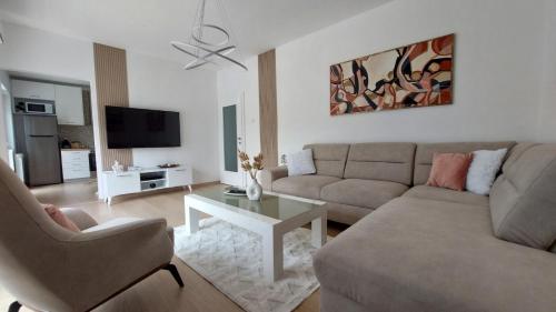 a living room with a couch and a table at MINA modern & cozy apartment main city square GTC Skopje in Skopje