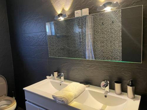 a bathroom with a sink and a shower with a mirror at Alojamento dos Remédios in Lamego