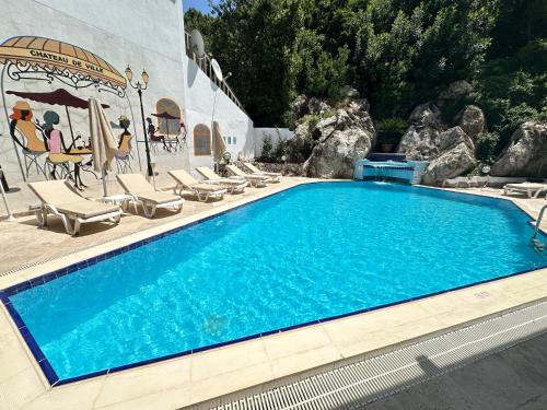 uma piscina com espreguiçadeiras e uma piscina em Hotel Chateau de Ville em Marmaris