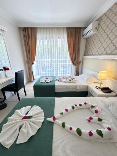 a hotel room with two beds with flowers on them at Hotel Chateau de Ville in Marmaris