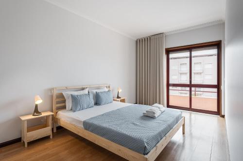 sypialnia z dużym łóżkiem i oknem w obiekcie GuestReady - Cosy Hideaway in Vila do Conde w mieście Vila do Conde