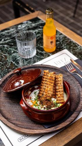 a plate with a bowl of food on a table at Jacuzzi suite Piazza dei Leoni in Heraklio Town