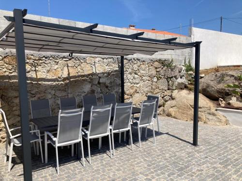 grupa krzeseł i stół pod baldachimem w obiekcie GuestReady - A cosmopolitan stay in Esposende w mieście Belinho