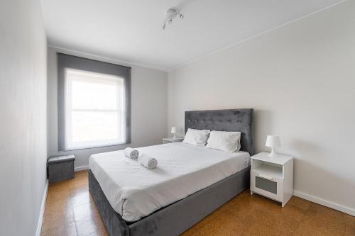 a white bedroom with a large bed and a window at GuestReady - Charm stay in Senhora da Hora in Senhora da Hora