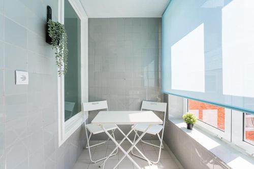 ein Esszimmer mit einem weißen Tisch und 2 Stühlen in der Unterkunft GuestReady - Charm stay in Senhora da Hora in Senhora da Hora