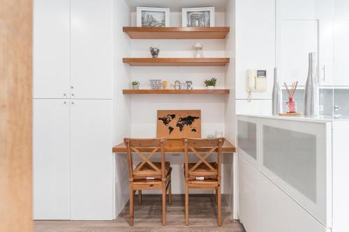 una cucina con tavolo e sedie in legno di GuestReady - Bright Studio with balcony a Vila Nova de Gaia
