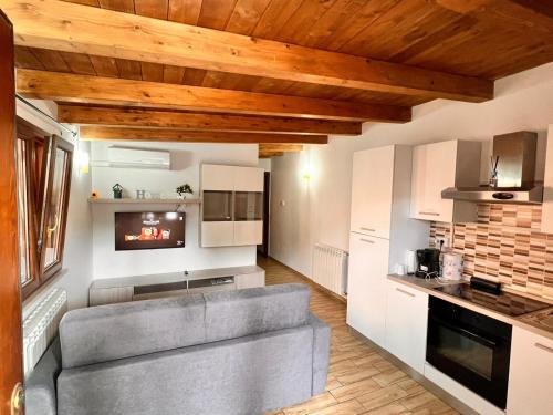 a living room with a gray couch in a kitchen at Sunrise Home in Porto