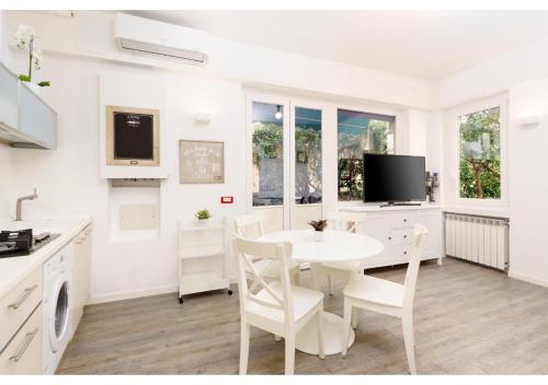 biała kuchnia z białym stołem i krzesłami w obiekcie Diamante Sea Apartment w mieście Varigotti